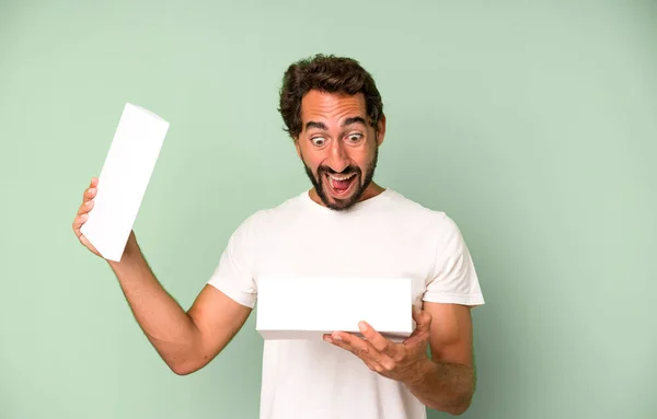 Young Crazy Bearded Expressive Man Holding Blank Packaging Box — Stock Photo, Image