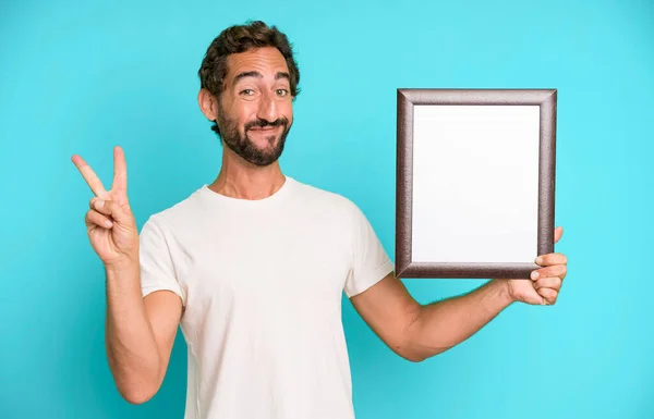 Jong Gek Bebaarde Expressieve Man Met Een Wit Leeg Frame — Stockfoto