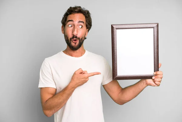 Jong Gek Bebaarde Expressieve Man Met Een Wit Leeg Frame — Stockfoto