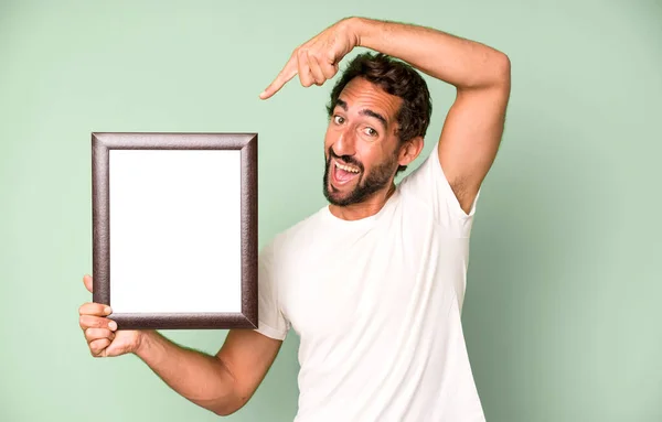 Jong Gek Bebaarde Expressieve Man Met Een Wit Leeg Frame — Stockfoto