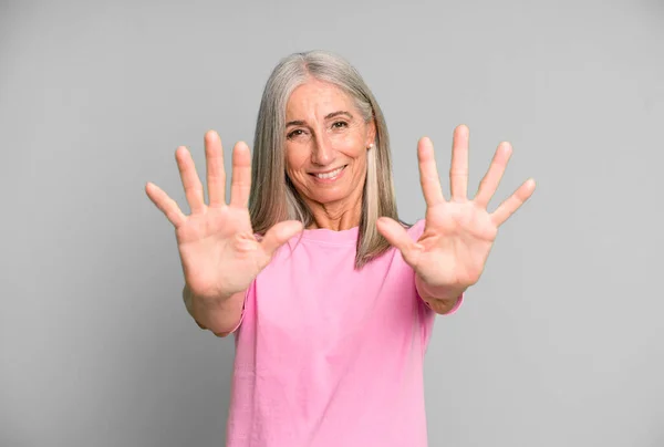 Hübsche Graue Haare Seniorin Lächelt Und Schaut Freundlich Zeigt Zahl — Stockfoto