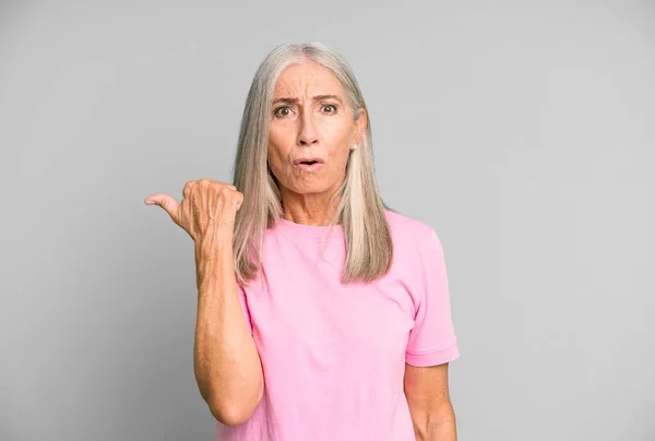 Hübsche Graue Haare Seniorin Schaut Erstaunt Ungläubig Zeigt Auf Gegenstand — Stockfoto