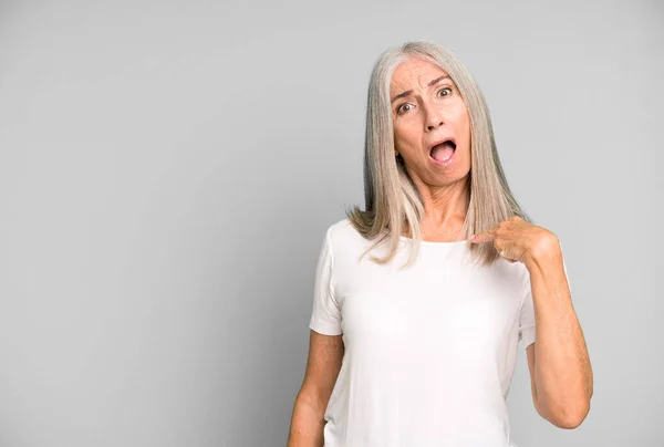 灰色の髪のきれいな女性がショックを受けて 口を大きく開いて驚いて 自分自身を指している コピースペースのコンセプト — ストック写真