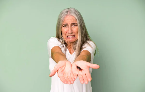 Gri Saçlı Yaşlı Güzel Bir Kadın Parmaklarıyla Bir Böcek Tutuyor — Stok fotoğraf