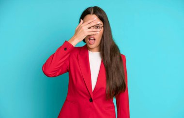 İspanyol güzel kadın şok olmuş, korkmuş ya da korkmuş görünüyor. Kırmızı ceketle yüzünü kapatıyor. iş kavramı