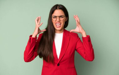 İspanyol asıllı güzel bir kadın ellerini havaya kaldırıp kırmızı ceketle bağırıyor. iş kavramı