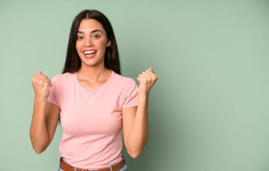 İspanyol güzel kadın şokta, gülüyor ve başarıyı kutluyor. boşluk konseptini kopyala