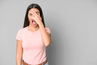 İspanyol güzel kadın şok olmuş, korkmuş ya da korkmuş görünüyor, yüzünü elleriyle kapatıyor. boşluk konseptini kopyala