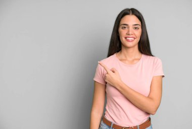 İspanyol güzel kadın neşeyle gülümsüyor, mutlu hissediyor ve bir tarafı işaret ediyor. boşluk konseptini kopyala