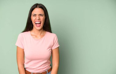 İspanyol güzel kadın agresif bir şekilde bağırıyor, çok kızgın görünüyor. boşluk konseptini kopyala