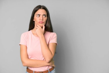 Hispanik güzel kadın düşünüyor, kuşkulu ve şaşkın hissediyor. boşluk konseptini kopyala