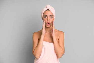 İspanyol güzel kadın kendini mutlu hissediyor, elleri ağzının kenarında bağırıyor. Bornoz ve güzellik konsepti