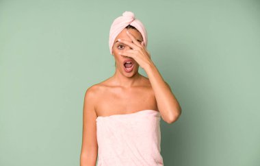 İspanyol güzel kadın şok olmuş, korkmuş ya da korkmuş görünüyor, yüzünü elleriyle kapatıyor. Bornoz ve güzellik konsepti