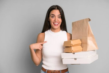 İspanyol güzel kadın kendini mutlu hissediyor ve heyecanla kendini işaret ediyor. boş ambalaj kutularını kaldır