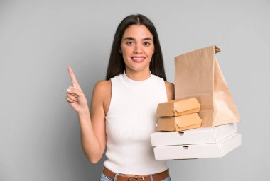 İspanyol güzel kadın gülümsüyor ve arkadaş canlısı görünüyor, bir numarayı gösteriyor. boş ambalaj kutularını kaldır