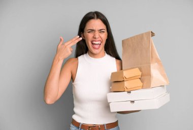 İspanyol güzel kadın mutsuz ve stresli görünüyor, intihar jesti silah işareti yapıyor. boş ambalaj kutularını kaldır