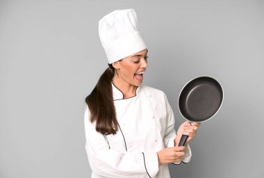 İspanyol, genç, yetişkin ve kızartma tavası konsepti olan etkileyici bir kadın şef.