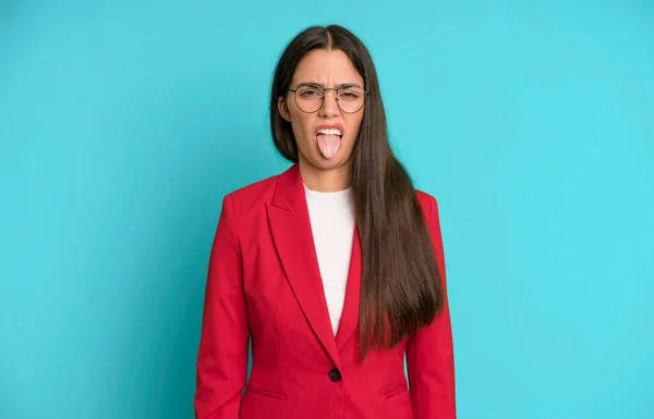 ヒスパニックかわいい女はうんざりしていらいらして舌を赤いブレザーで出す ビジネスコンセプト — ストック写真