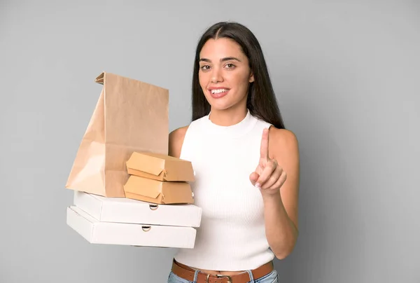 自信を持って1位の笑顔を見せるパニック系の可愛い女性 空の包装箱を取り上げ — ストック写真