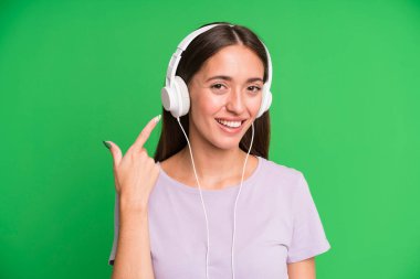 Genç ve güzel bir kadın kulaklıklarıyla müzik dinliyor.