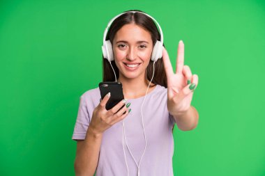 Genç ve güzel bir kadın kulaklıklarıyla müzik dinliyor.