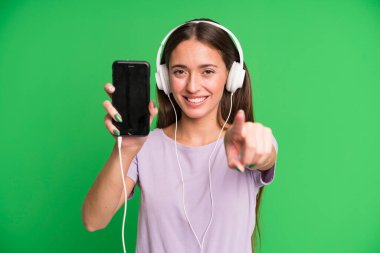 Genç ve güzel bir kadın kulaklıklarıyla müzik dinliyor.