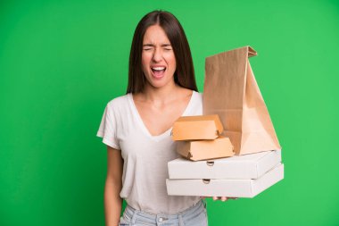 Genç ve güzel bir kadın agresif bir şekilde bağırıyor. Kağıt maketi ile çok kızgın görünüyor. Fast food paketlerini alıp götürüyor.