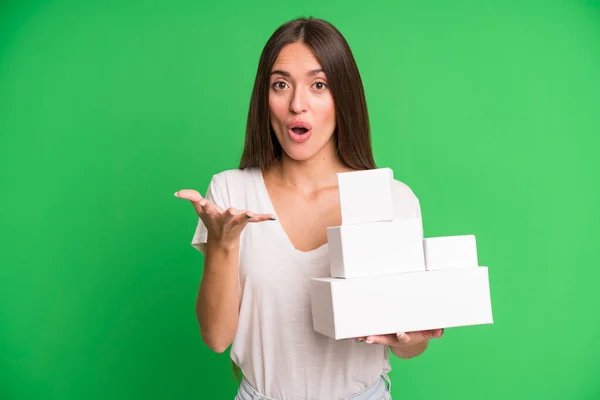 年轻漂亮的女人对一个空的白色纸盒包装模型感到非常震惊和惊讶 — 图库照片