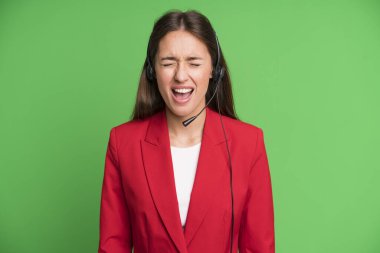 young pretty woman shouting aggressively, looking very angry. telemarketing concept