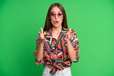 Genç ve güzel bir kadın şok olmuş ve şaşırmış hissediyor. yaz ve güneş gözlüğü konsepti