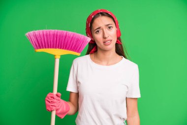 Genç ve güzel bir kadın şaşkın ve şaşkın hissediyor. Temizlikçi ve temizlik konsepti