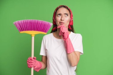 Genç, güzel bir kadın düşünüyor, kuşkulu ve şaşkın hissediyor. Temizlikçi ve temizlik konsepti