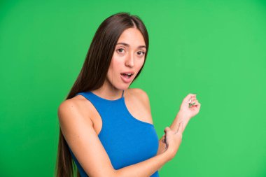 İspanyol güzel kadın şaşkın ve şaşkın hissediyor, kenarda fotokopi alanını işaret ederek, şaşkın, açık ağızlı bir görünüm ile