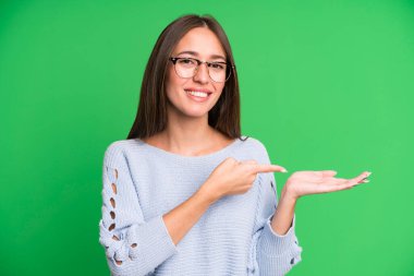İspanyol güzel kadın gülümsüyor, mutlu, kaygısız ve tatmin olmuş hissediyor, fotokopi alanındaki konsepte ya da fikre işaret ediyor.