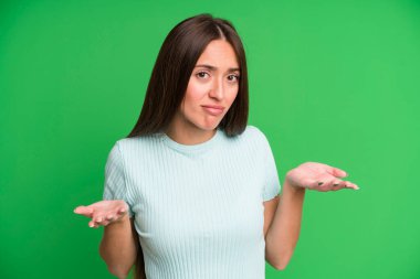 hispanic pretty woman feeling clueless and confused, having no idea, absolutely puzzled with a dumb or foolish look