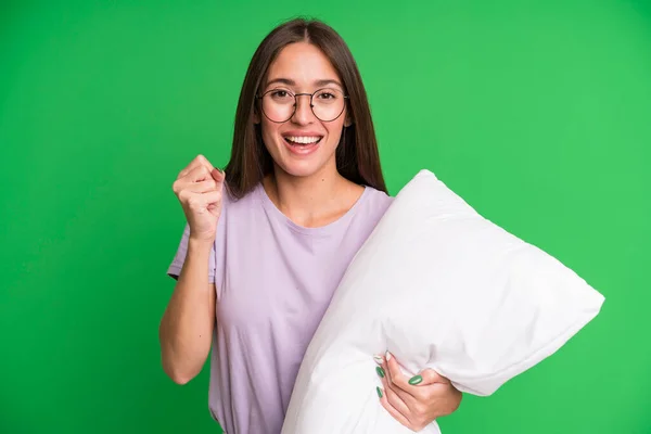 若い女性はショックを受けて笑って成功を祝っています パジャマと枕付きのナイトウェア — ストック写真