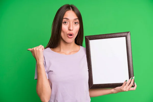 Young Pretty Woman Looking Astonished Disbelief Empty Blank Picture Frame — Stock Photo, Image