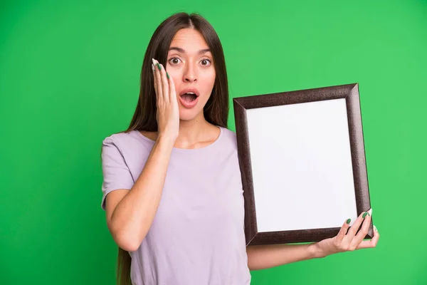 Young Pretty Woman Feeling Shocked Scared Empty Blank Picture Frame — Stock Photo, Image