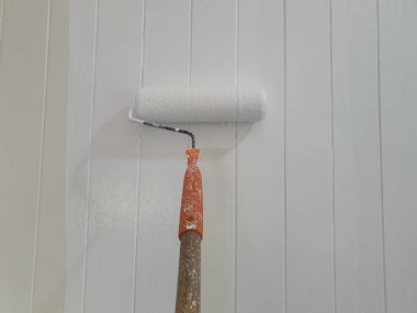 İnşaat işçileri, binaya yeni bir görünüm kazandırmak için sol duvarı asmak için boya silindiri kullanıyorlar..