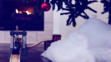 Yanan şöminenin önündeki Noel ağacının altında oyuncak tren. Bayram günleri için iyi titreşimler sağlıyor.