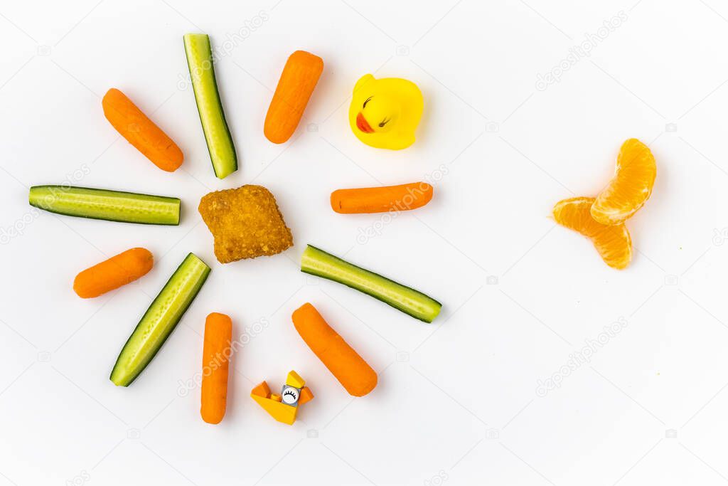 Arrangement of kids meal choices with spread toy blocks and a rubber ducky around it on white background