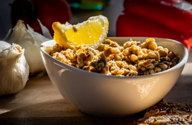 Haşlanmış ve baharatlı mercimek, beyaz kâsede limon dilimiyle süslenmiş.