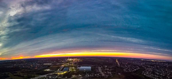 Ark of golden light during dramatic sunset observed by drone over Brannon Crossing Road Shopping Center in Nicolasville, Kentucky USA