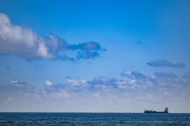 Fort Lauderdale okyanus kıyısında ufukta yük gemisi ve küçük deniz gemileri var.