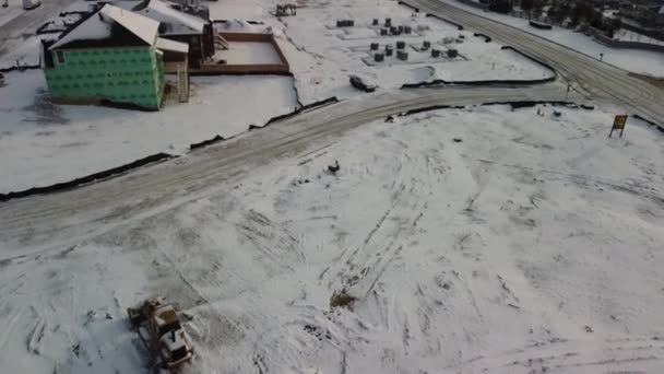 開発の初期段階で新しい住宅の雪の建設現場で覆われた飛行 — ストック動画