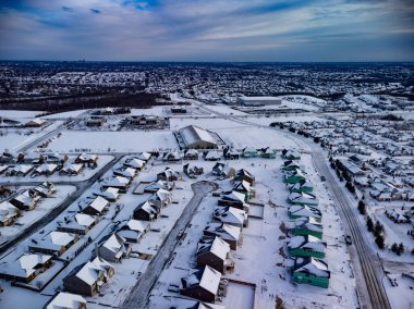 Bazıları hala Lexington, KY 'nin dış mahallelerinde inşaat aşamasında olan ve şehrin merkezi uzak ufukta görünen karlarla kaplı yerleşim evleri..