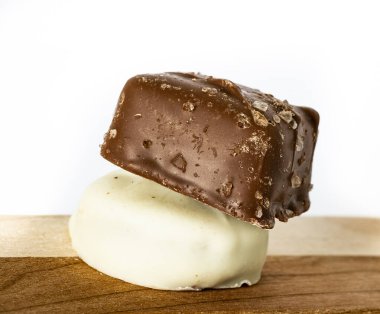 Beyaz çikolata ve tuz kristalleri farklı renklerde iki tahta üzerine yerleştirilmiş şekerler.