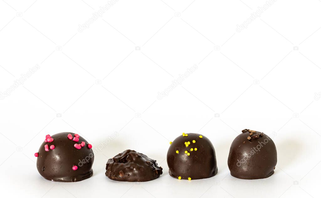 Variety of chocolate candy pieces in a row isolated on white background