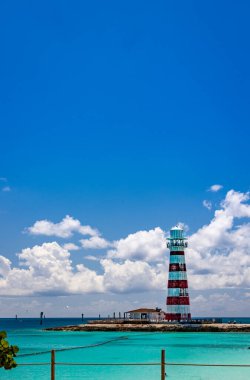 Tropik bir adada körfez çağında beyaz ve kırmızı çizgilerle boyanmış tipik deniz feneri.
