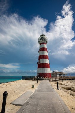 Bir deniz feneri, tropikal plajda ona giden bir yol var.